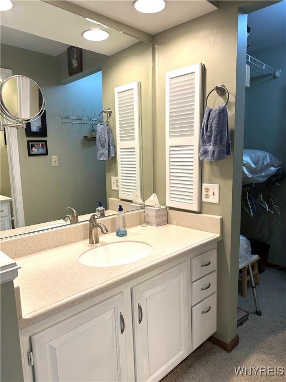 bathroom featuring vanity and a walk in closet