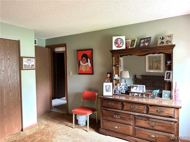 sitting room with carpet flooring and a textured ceiling