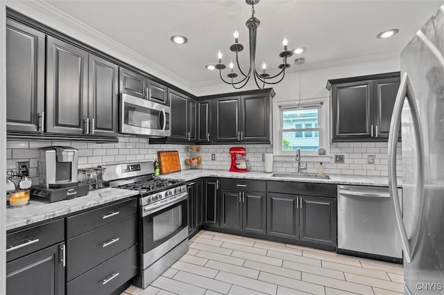 kitchen with appliances with stainless steel finishes, a sink, crown molding, decorative backsplash, and light stone countertops