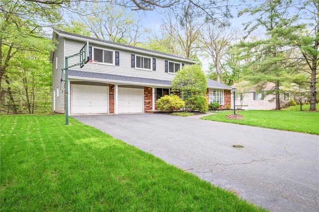 traditional-style home with asphalt driveway, a garage, a front lawn, and brick siding