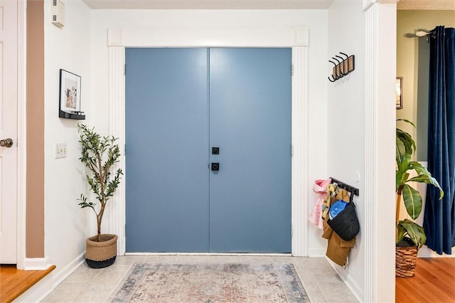 foyer entrance with baseboards and tile patterned floors