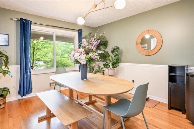 dining area featuring light wood-style flooring, baseboards, and a chandelier