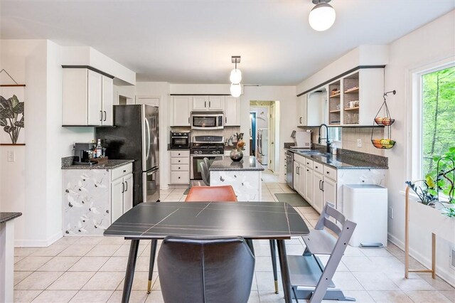 kitchen with stainless steel appliances, a sink, light tile patterned floors, and open shelves