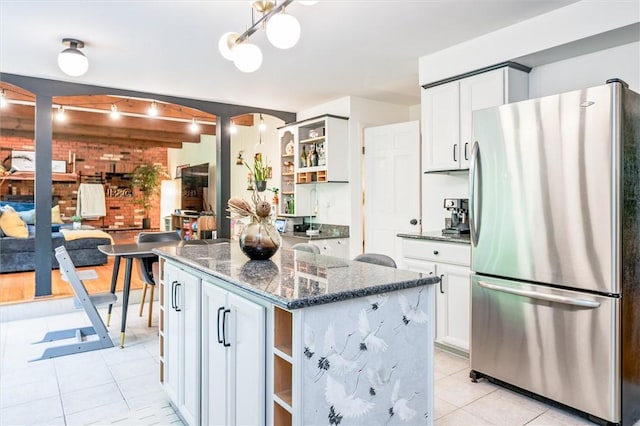 kitchen with freestanding refrigerator, open shelves, light tile patterned floors, a kitchen island, and white cabinets