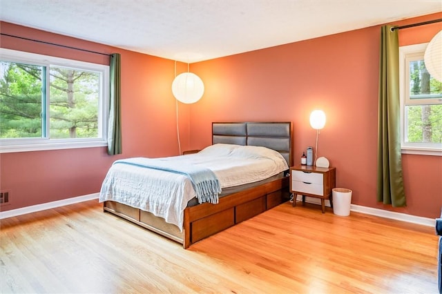 bedroom featuring wood finished floors and baseboards
