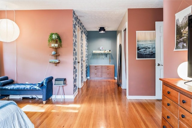 bedroom with baseboards and light wood finished floors