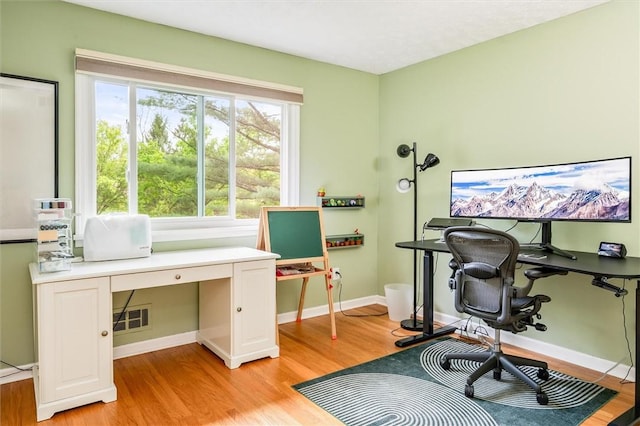 office area with light wood-style flooring and baseboards
