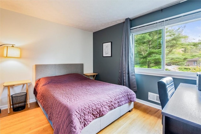 bedroom with wood finished floors and baseboards