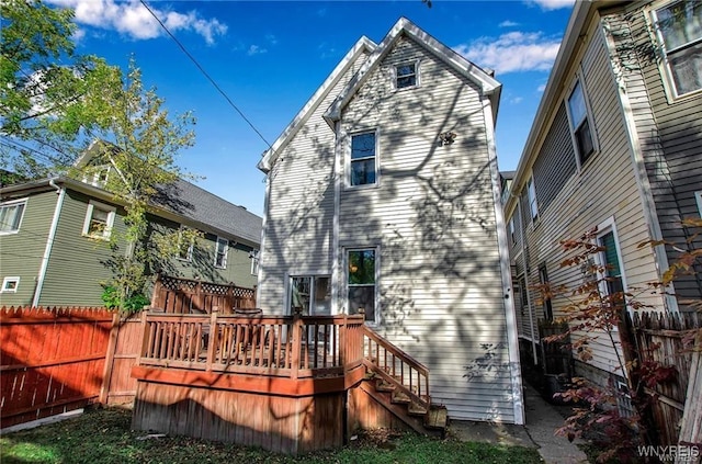 back of property featuring a deck and fence