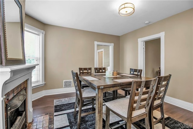 dining space featuring baseboards, dark wood finished floors, and healthy amount of natural light