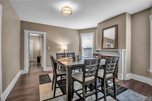 dining space featuring dark wood-style floors and baseboards