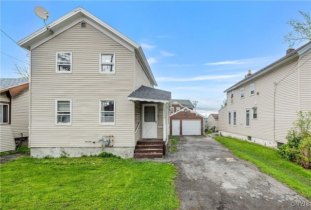 view of front of property featuring a garage, driveway, a front yard, an outdoor structure, and entry steps