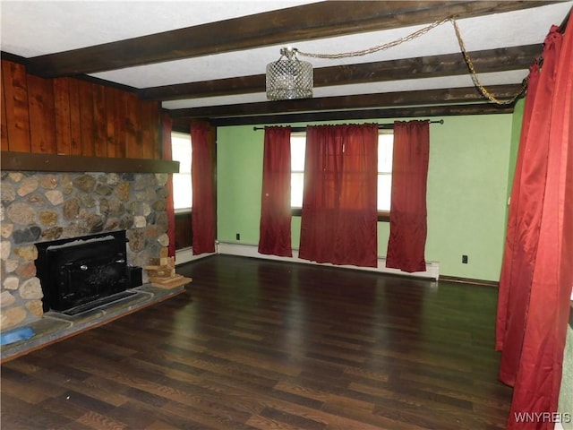 unfurnished living room featuring beam ceiling, wood finished floors, a stone fireplace, and baseboards