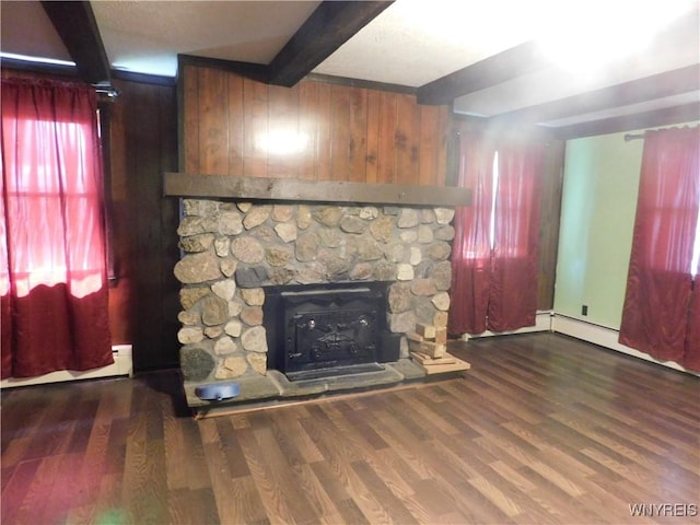 unfurnished living room with beam ceiling, wooden walls, wood finished floors, and a fireplace