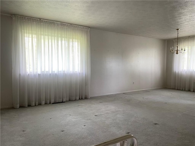 120 Bradley Ct, Horseheads, NY 14845 - empty room featuring a chandelier, a textured ceiling, carpet flooring, and baseboards