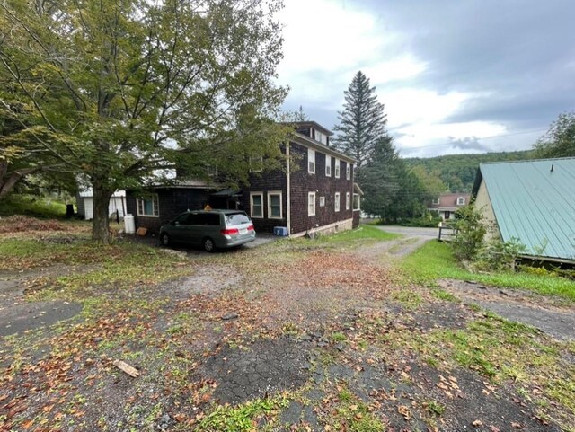 view of side of property featuring dirt driveway