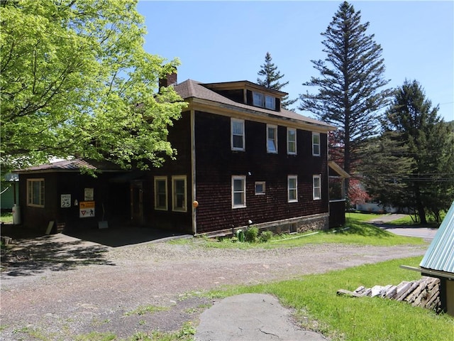 view of property exterior with a chimney and dirt driveway