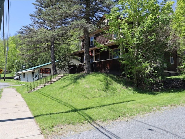 view of front facade featuring a front lawn and stairs