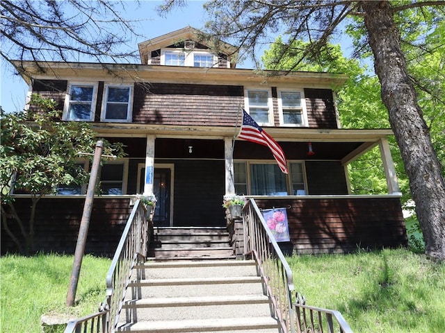 american foursquare style home featuring covered porch and stairs