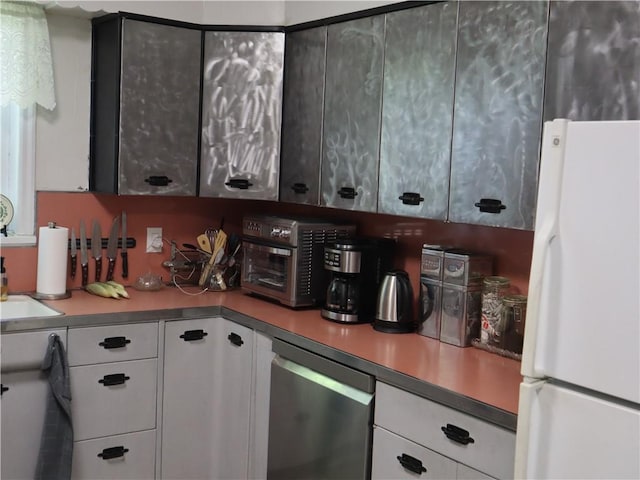 kitchen featuring freestanding refrigerator, white cabinetry, stainless steel dishwasher, and light countertops