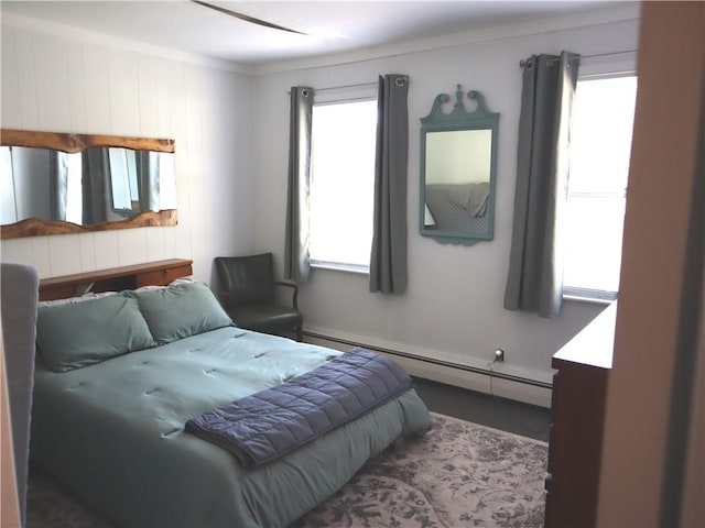 bedroom featuring baseboard heating and multiple windows