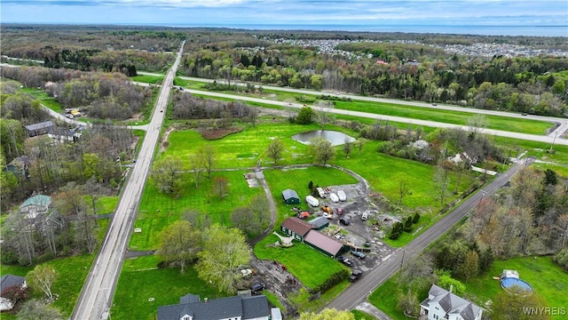 aerial view of property's location featuring a nearby body of water and a heavily wooded area