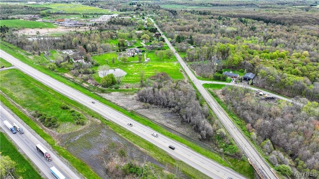 aerial overview of property's location featuring a main thoroughfare and a forest