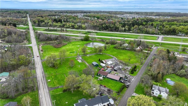 aerial overview of property's location featuring a nearby body of water and a heavily wooded area