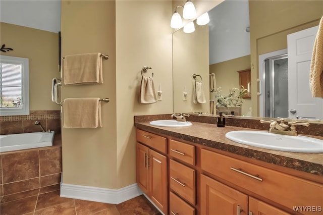 bathroom with tile patterned floors, double vanity, a stall shower, a bath, and baseboards