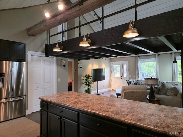1003 Waterview Dr, Vienna, NY 13308 - kitchen with stainless steel fridge with ice dispenser, open floor plan, beam ceiling, a high ceiling, and dark cabinets