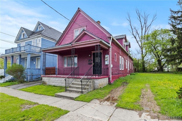 75 Box Ave, Buffalo, NY 14211 - view of front of house featuring covered porch, a chimney, and a front lawn