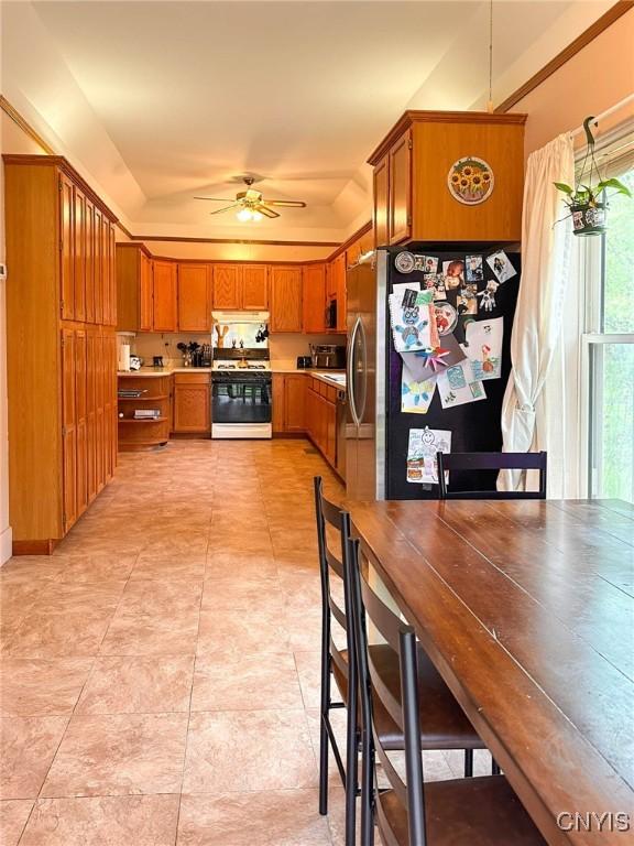 237 James St, Lenox, NY 13032 - kitchen featuring gas stove, freestanding refrigerator, brown cabinets, and ceiling fan