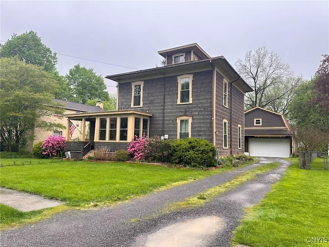 237 James St, Lenox, NY 13032 - view of home's exterior featuring a garage, driveway, a lawn, and a sunroom