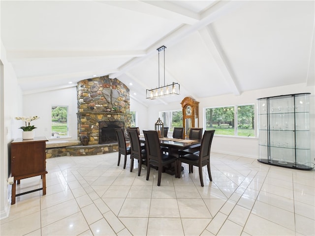 dining space with light tile patterned floors, a stone fireplace, healthy amount of natural light, and baseboards