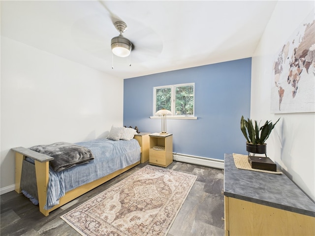 bedroom featuring baseboard heating, baseboards, wood finished floors, and a ceiling fan