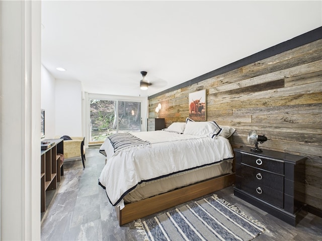 bedroom with wooden walls and ceiling fan