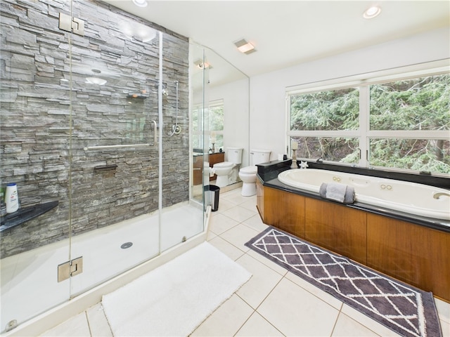 bathroom featuring a garden tub, tile patterned flooring, toilet, and a stall shower