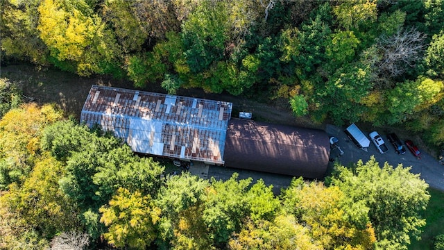 aerial view of property and surrounding area with a heavily wooded area