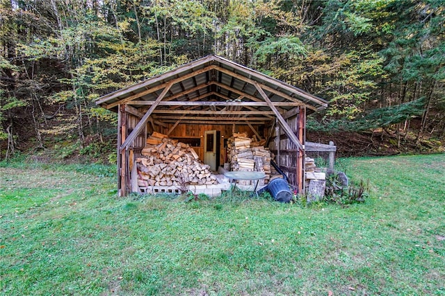 view of outbuilding featuring an outdoor structure and a forest view
