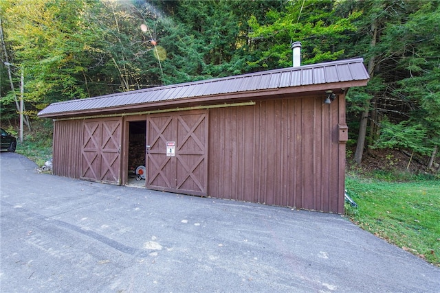 view of outbuilding with an outbuilding and a view of trees