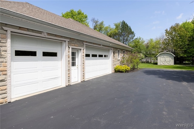 56 Sunset Ln, Orchard Park, NY 14127 - garage featuring driveway and a storage shed