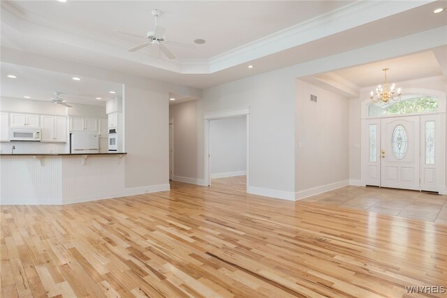 56 Sunset Ln, Orchard Park, NY 14127 - unfurnished living room with light wood finished floors, a ceiling fan, crown molding, recessed lighting, and a chandelier