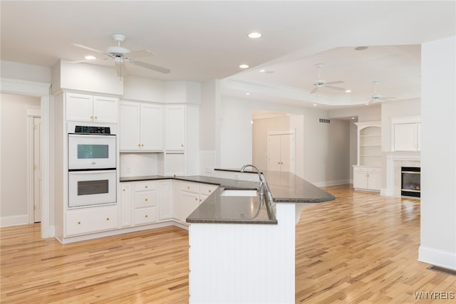 56 Sunset Ln, Orchard Park, NY 14127 - kitchen with a ceiling fan, a sink, double oven, a peninsula, and recessed lighting