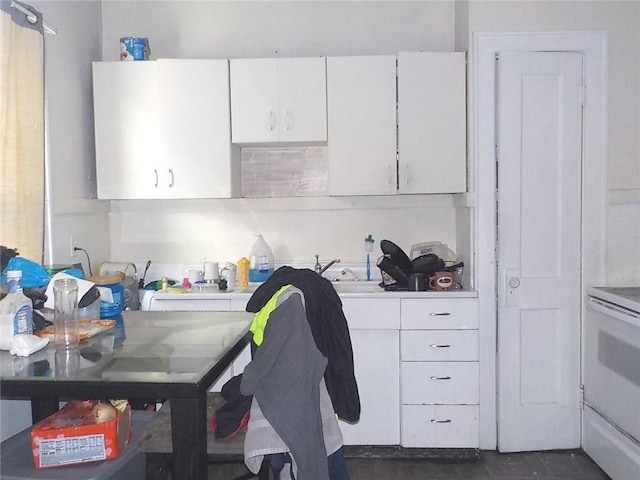 kitchen featuring white electric stove, white cabinetry, and light countertops