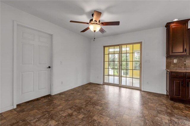 1275 Center St, Aurora, NY 14052 - unfurnished dining area with stone finish flooring, ceiling fan, and baseboards