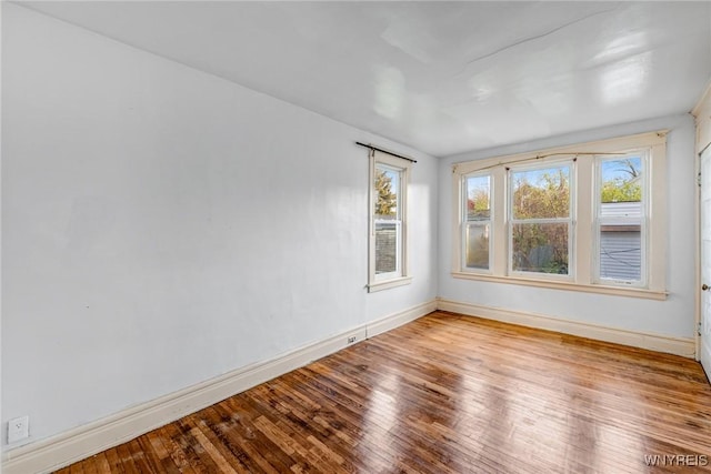 empty room featuring baseboards and hardwood / wood-style floors