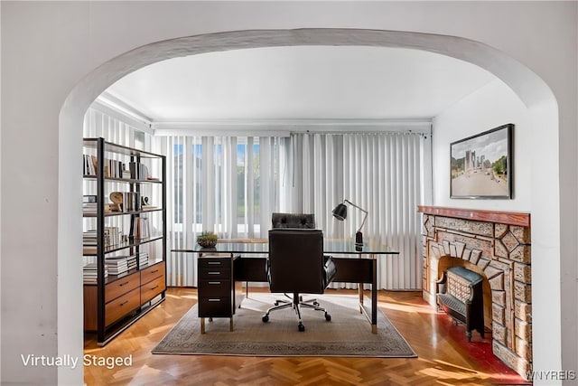 office space with arched walkways and a stone fireplace