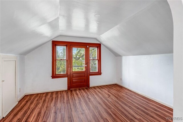 bonus room featuring wood finished floors, baseboards, and lofted ceiling