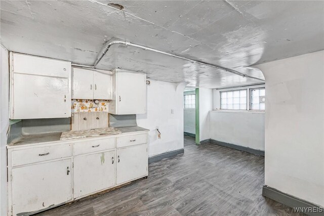 below grade area featuring baseboards and wood finished floors