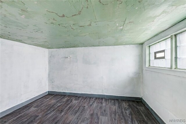 empty room featuring dark wood-style floors and baseboards